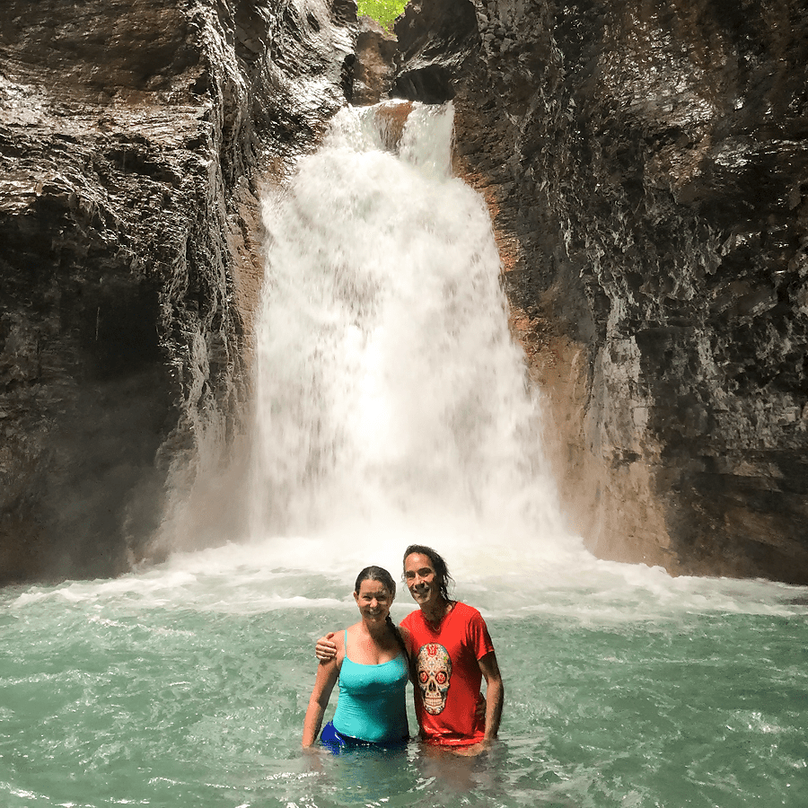 Couple standing in front of waterfall
