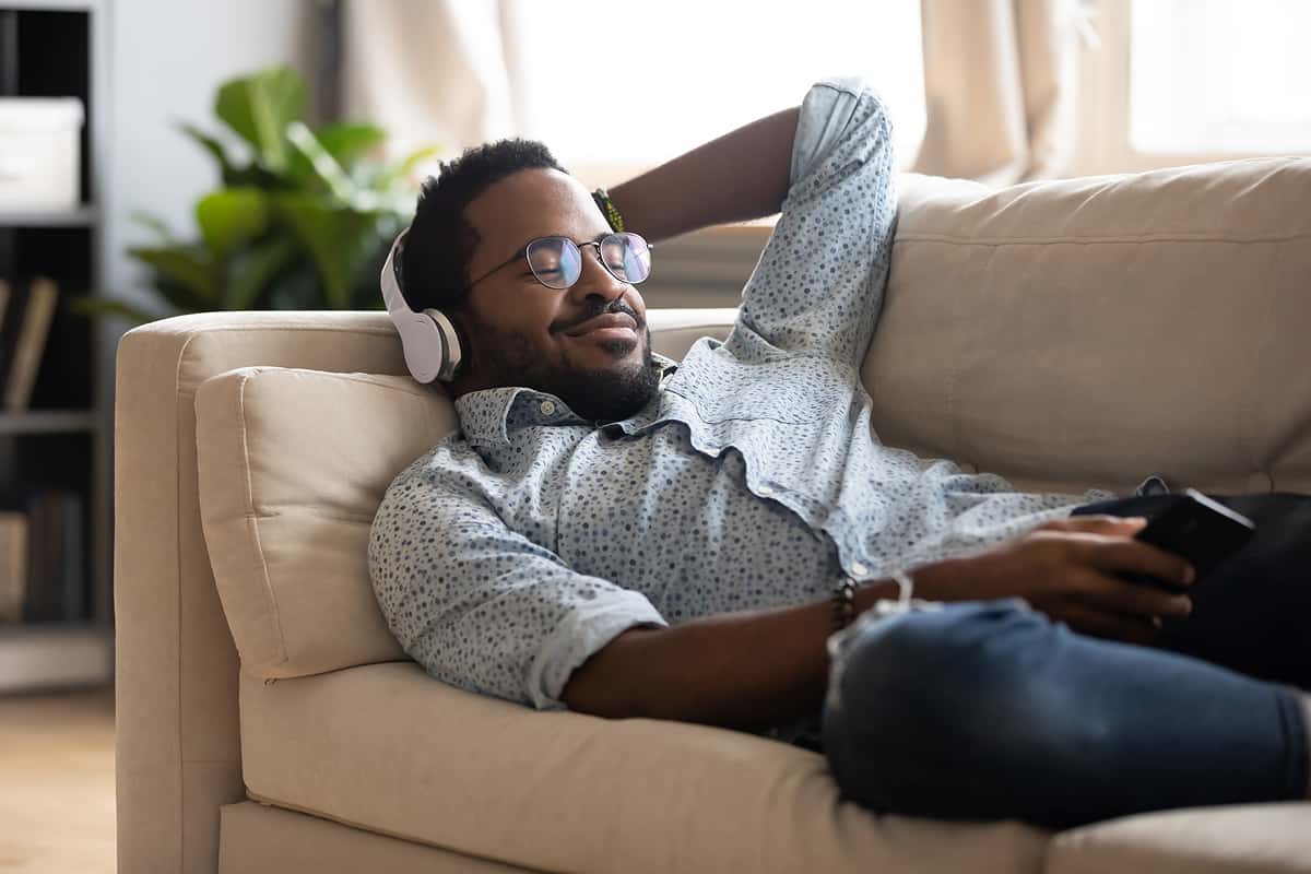 African American man relaxing on couch with headphones